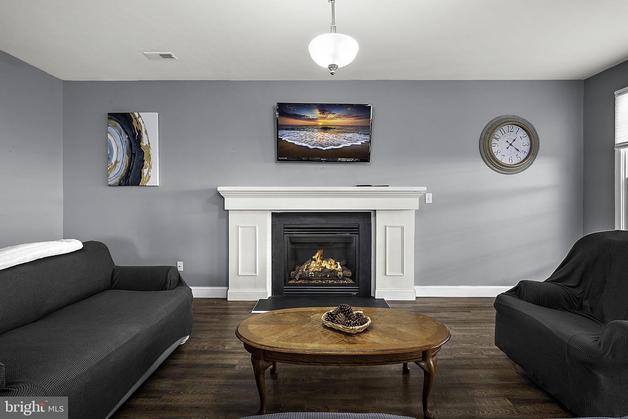 12167 Snug Harbor Road Berlin, MD 21811 - Photo 24 of 107 a living room with furniture a table and a fireplace