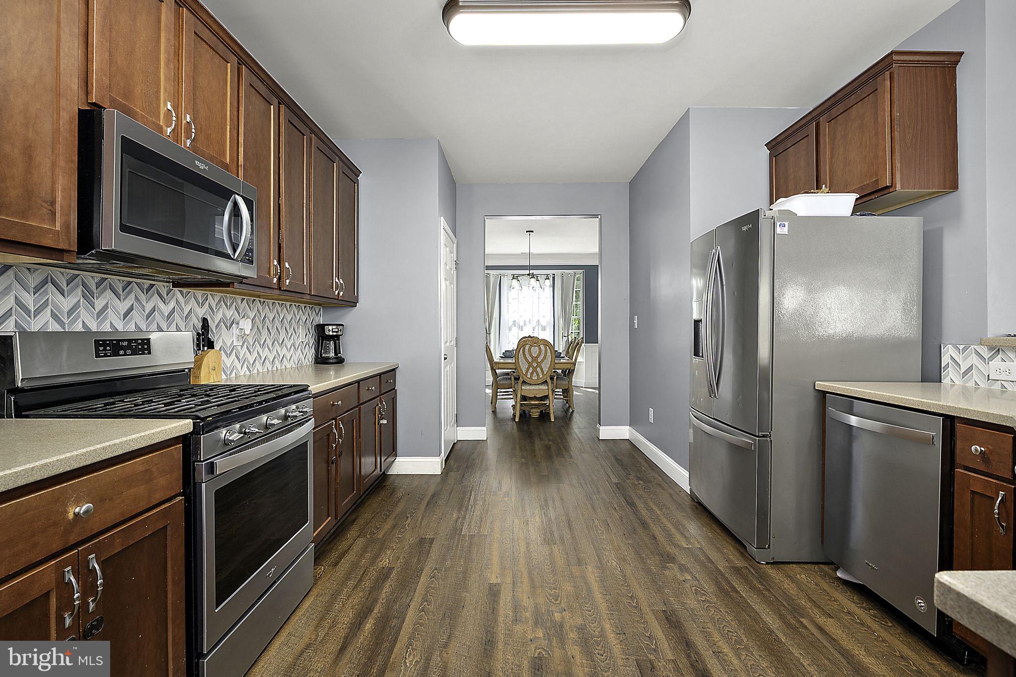 12167 Snug Harbor Road Berlin, MD 21811 - Photo 31 of 107 a kitchen with stainless steel appliances a stove microwave and refrigerator