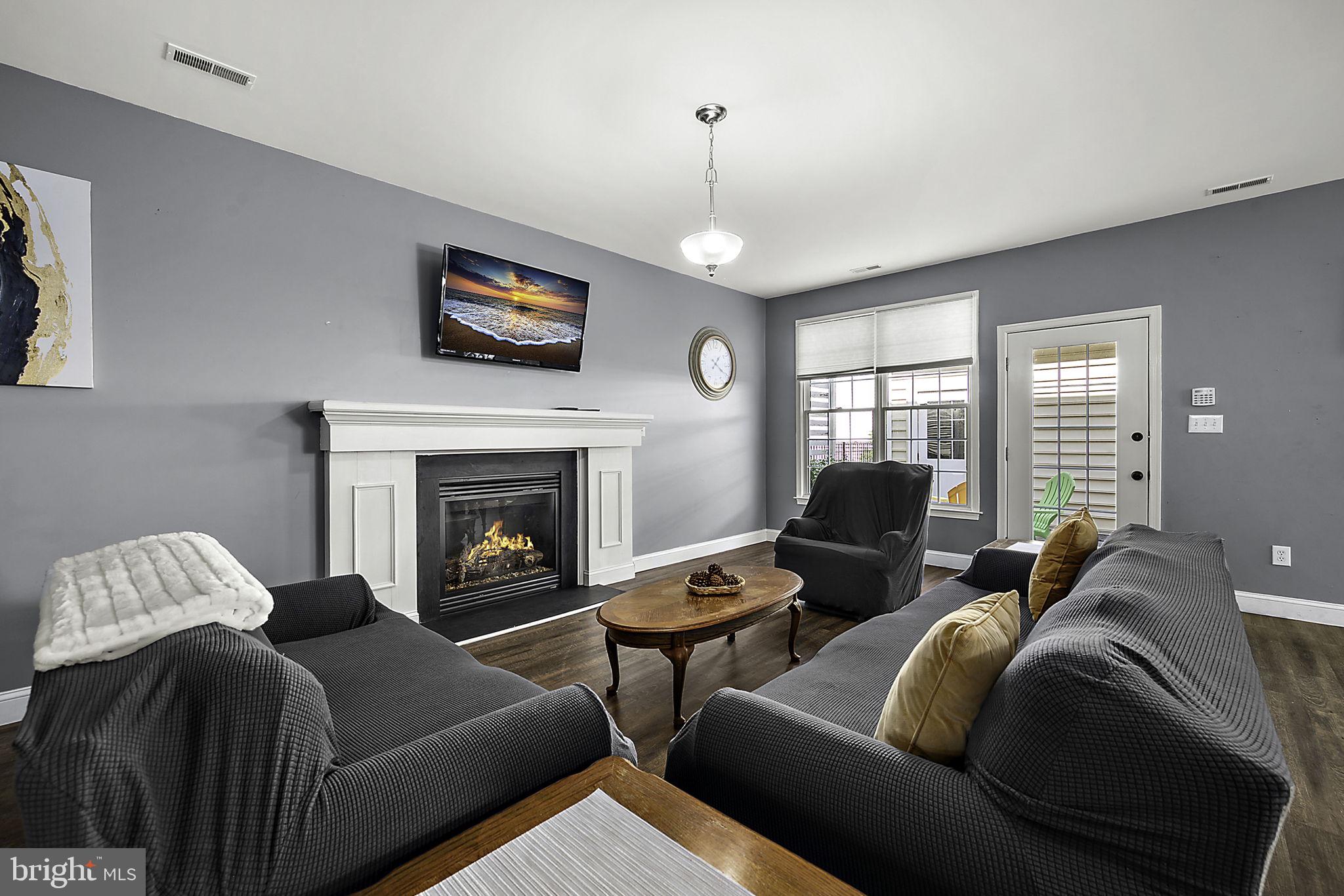 12167 Snug Harbor Road Berlin, MD 21811 - Photo 4 of 107 a living room with furniture a flat screen tv and a fireplace
