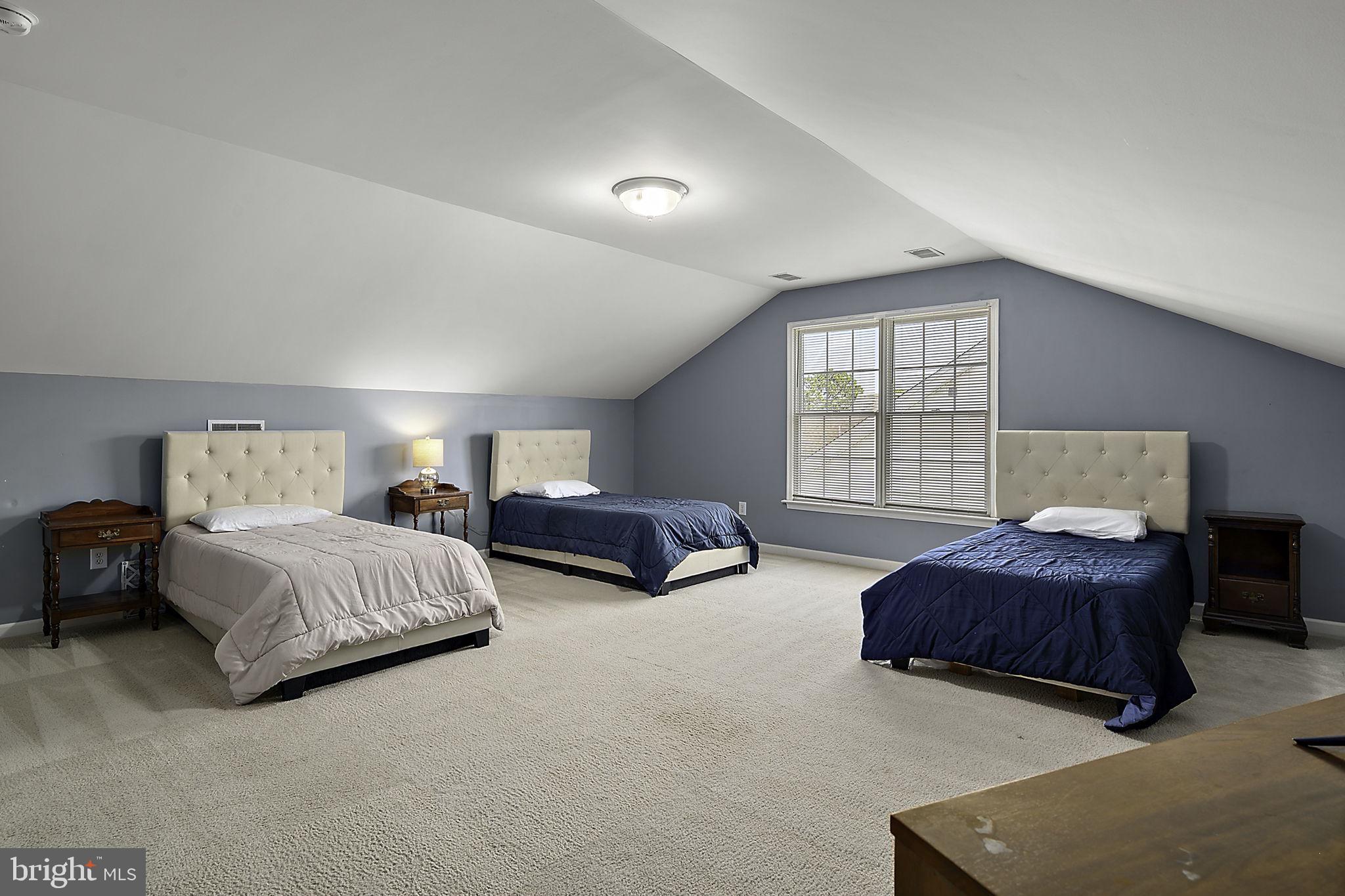 12167 Snug Harbor Road Berlin, MD 21811 - Photo 55 of 107 a spacious bedroom with a bed and a couch