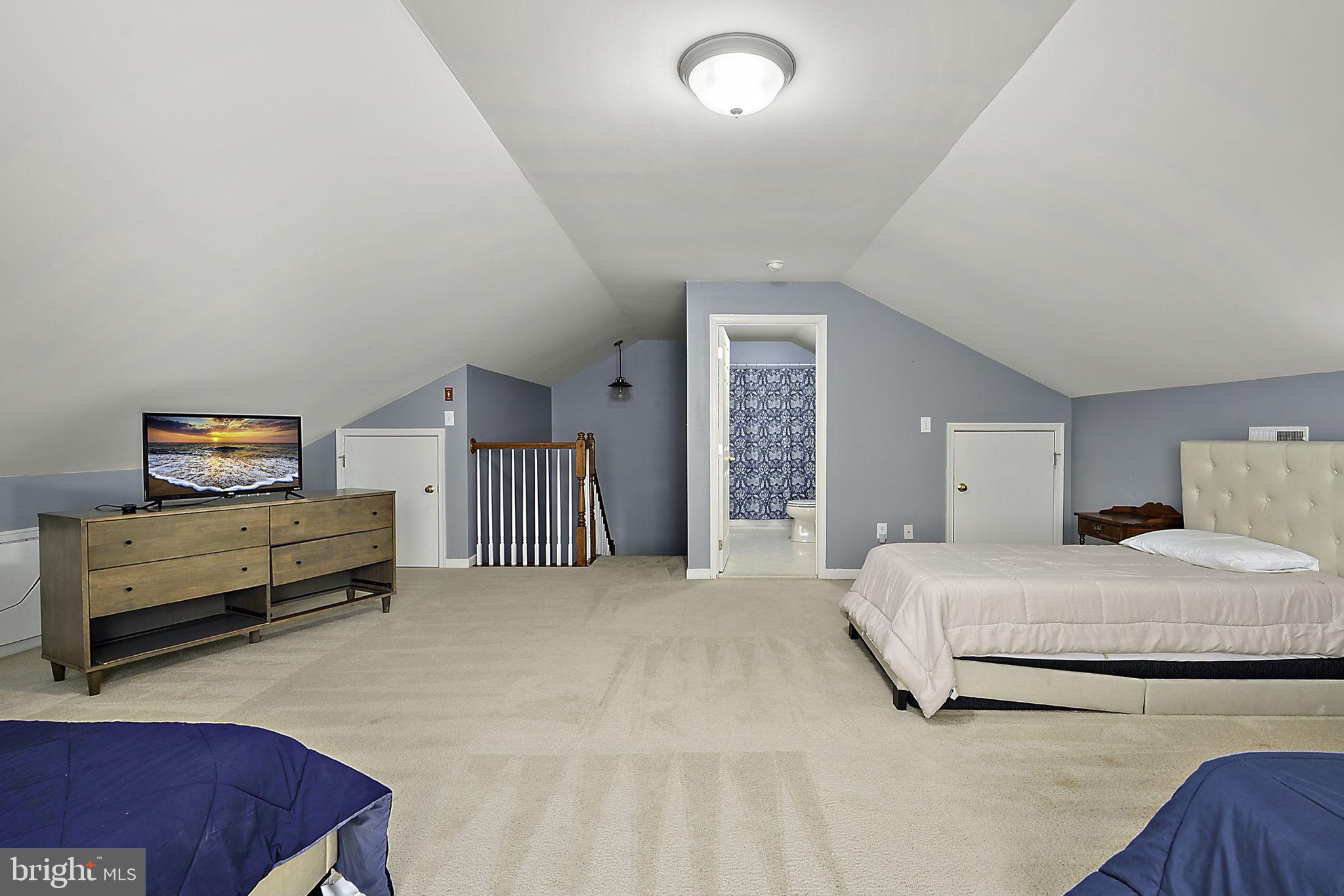 12167 Snug Harbor Road Berlin, MD 21811 - Photo 59 of 107 a spacious bedroom with a bed and a couch