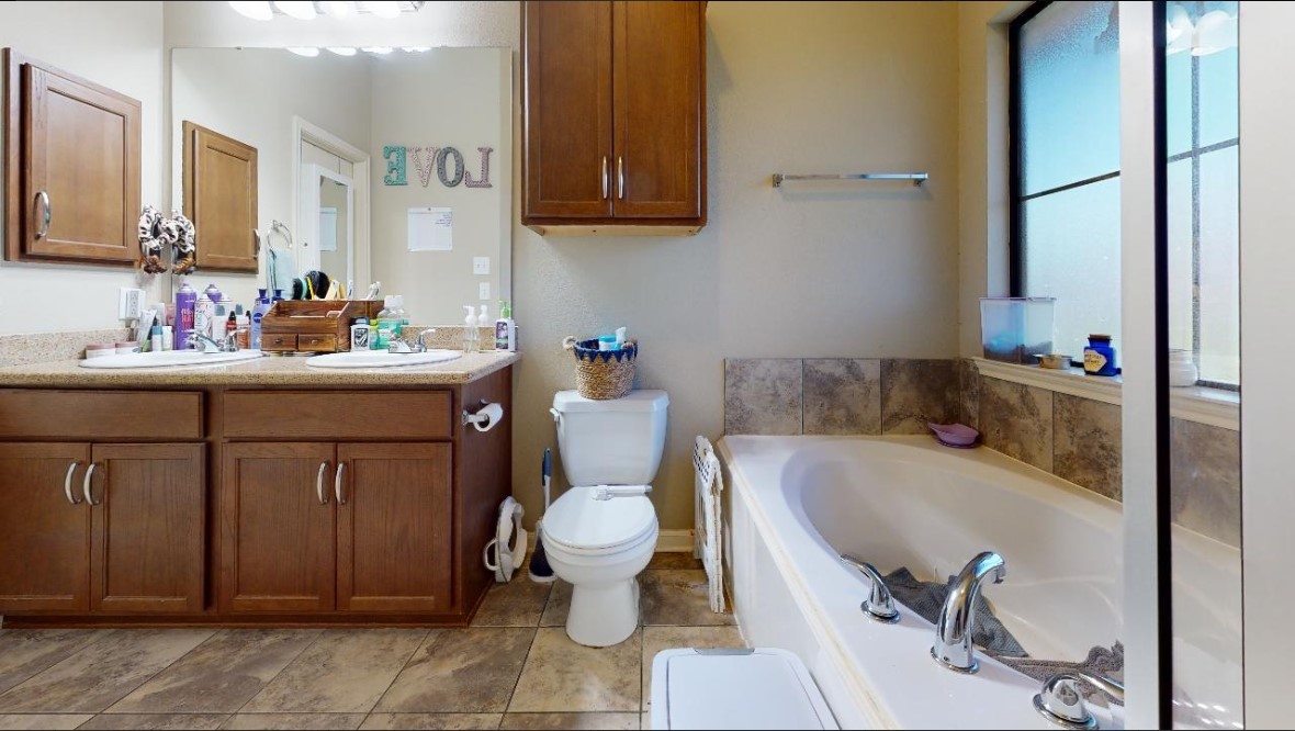 2015 Positano Loop Bryan, TX 77808 - Photo 13 of 15 a bathroom with a sink toilet and shower