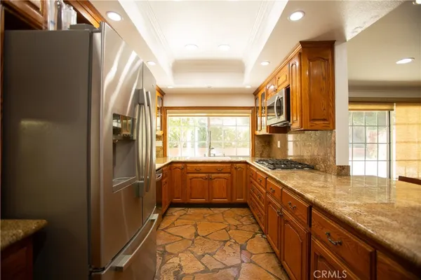 a kitchen with granite countertop a sink and a refrigerator
