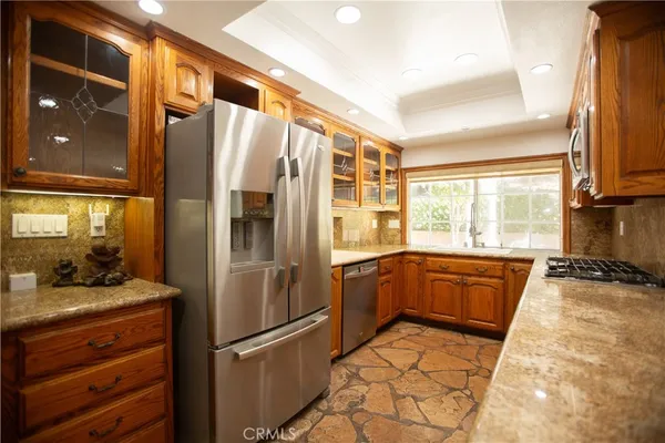 a kitchen with stainless steel appliances granite countertop a refrigerator and a sink