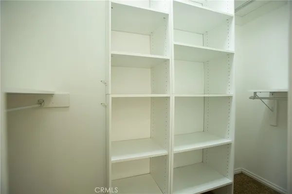 a view of walk in closet with empty racks
