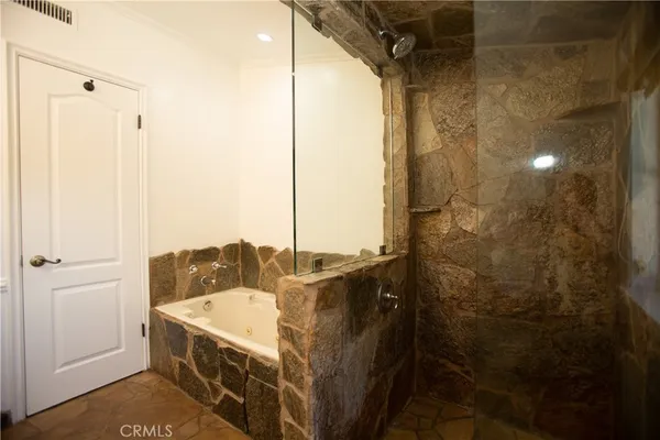 a bathroom with a granite countertop sink a mirror and shower