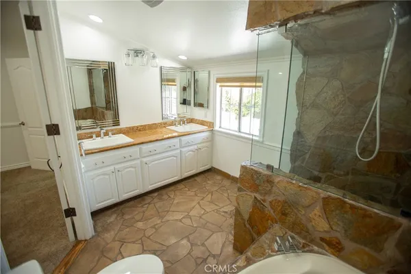 a bathroom with a granite countertop sink mirror and a bathtub