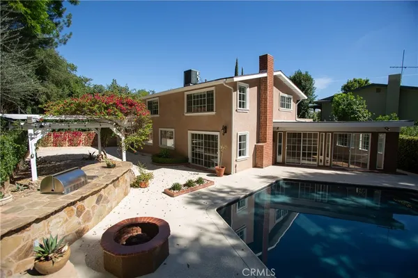 a view of a house with backyard and sitting area