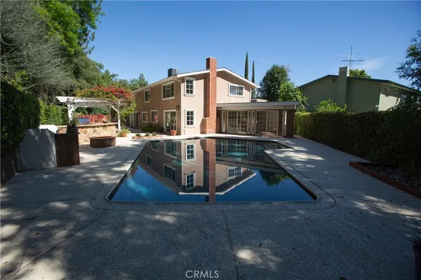 a view of a house with backyard and sitting area