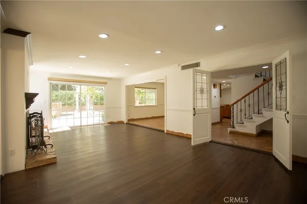 a view of a livingroom with wooden floor and a fireplace