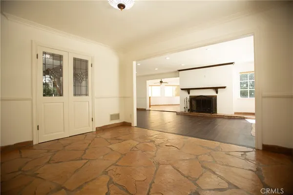 an empty room with floor to ceiling window and fire place