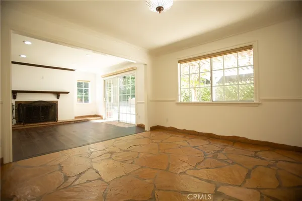a view of an empty room with a fireplace and a window