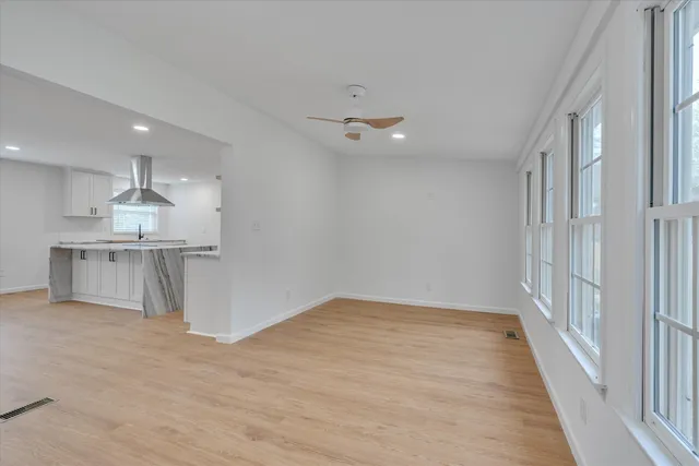 wooden floor in an empty room with a kitchen