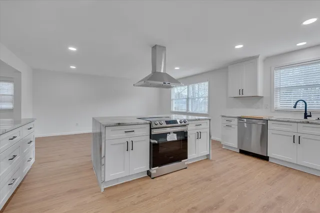 a kitchen with white cabinets stainless steel appliances and sink