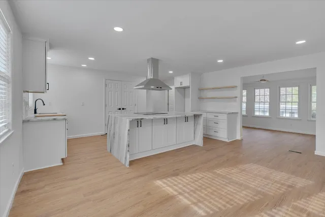 a view of kitchen with white cabinets and wooden floor