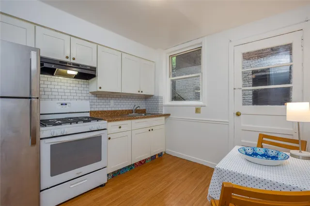 a kitchen with granite countertop cabinets stainless steel appliances and wooden floor