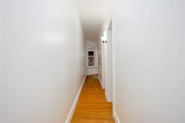 a view of a hallway with wooden floor