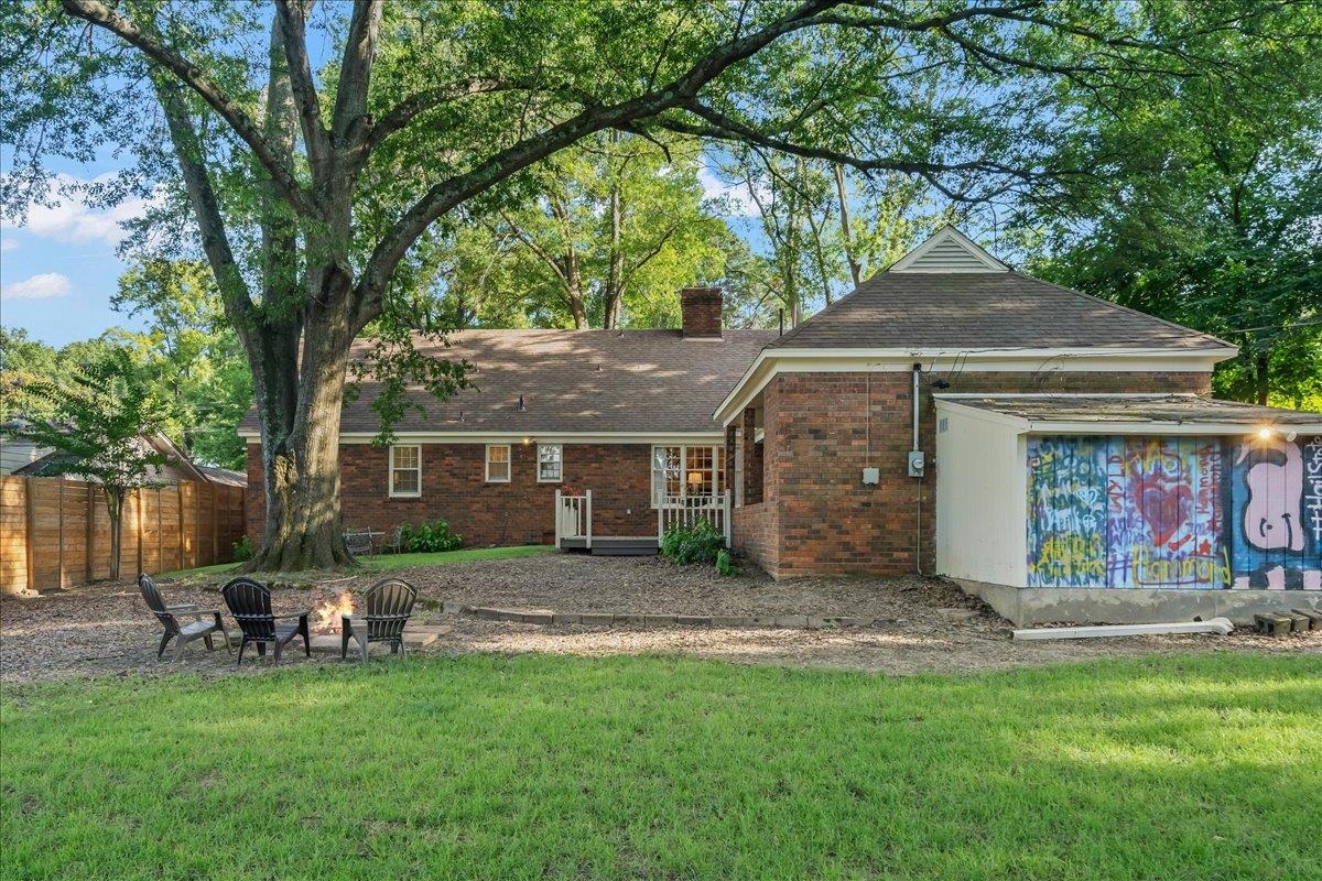 5376 Mason Road Memphis, TN 38120 - Photo 36 of 37 Rear view of property with a chimney, a shingled roof, brick siding, and a fire pit