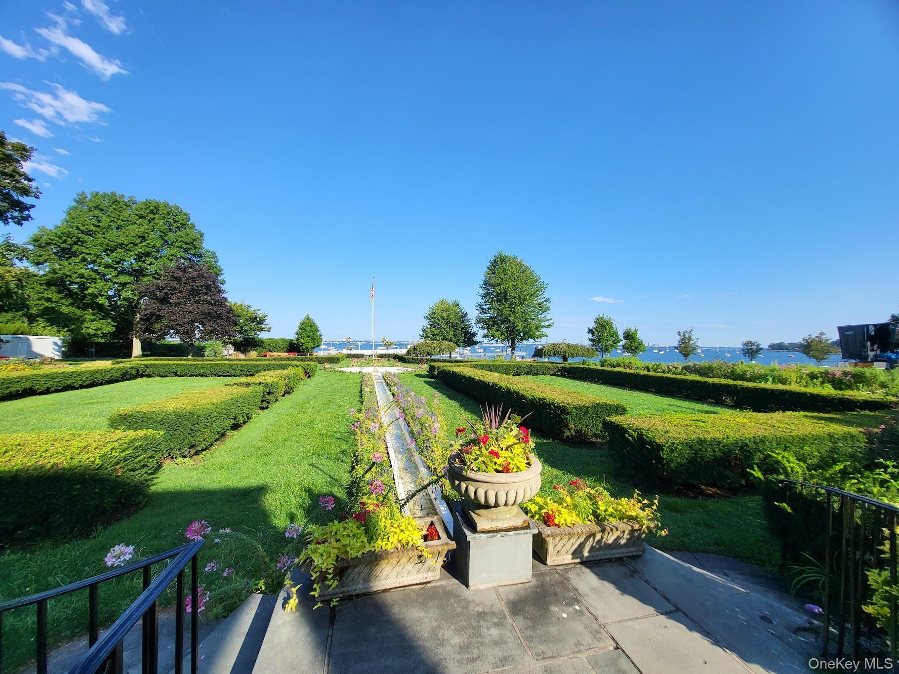 75 South Middle Neck Road, Unit 4G Great Neck, NY 11021 - Photo 33 of 37 a view of a lake with a bench under an umbrella