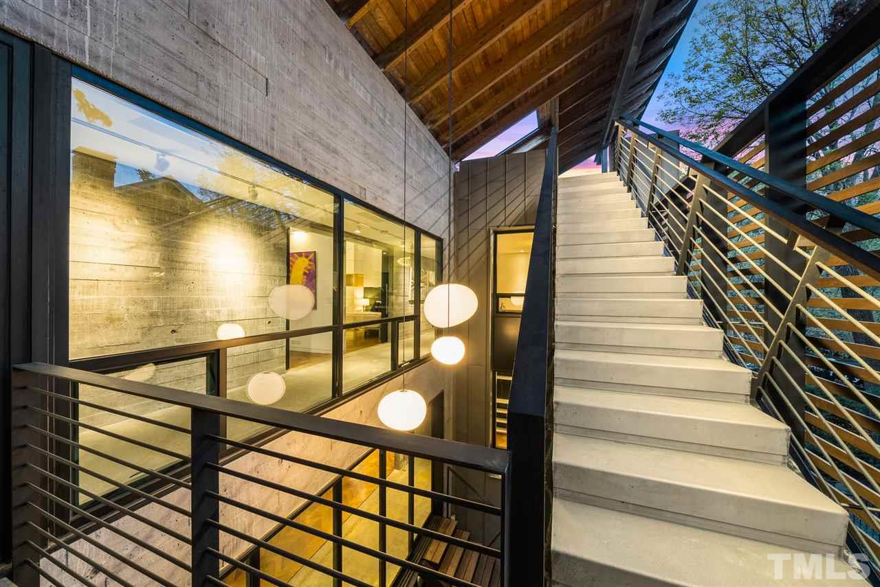 123 Hillcrest Road Raleigh, NC 27605 - Photo 2 of 30 pulled from the interior of the home, the glass-sleeved stair is a stunning focal point of the home, and celebrates vertical connection, reflection, light and shadow.