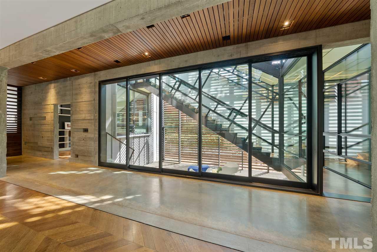 123 Hillcrest Road Raleigh, NC 27605 - Photo 9 of 30 the design of the home is like no other - as the hand build stair is enclosed with a sleeve of glass and steel, creating a stunning play of reflection and geometry