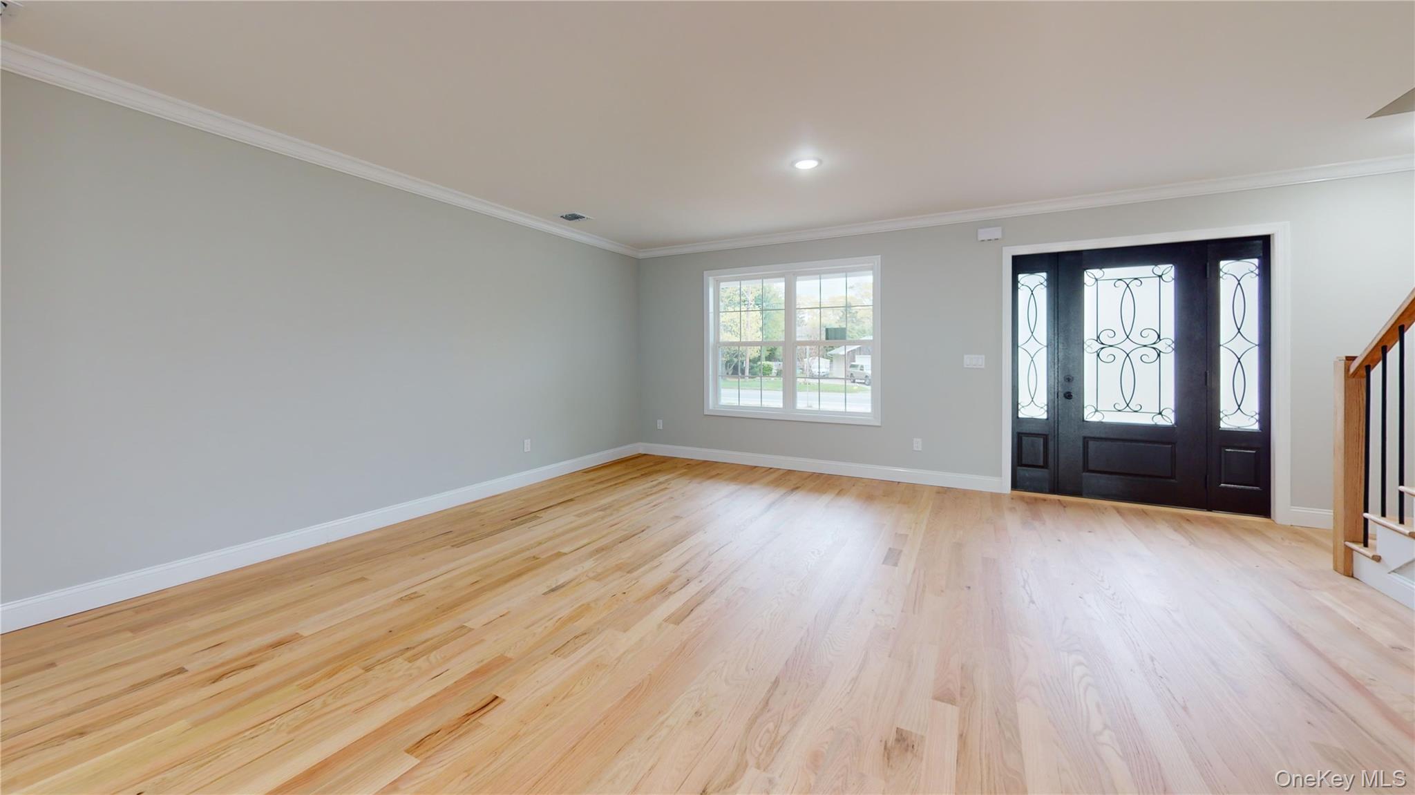 492 Blue Point Road Farmingville, NY 11738 - Photo 3 of 21 an empty room with wooden floor and windows