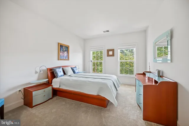 a bedroom with bed and a couch next to a window
