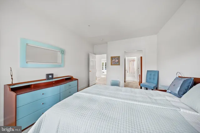 a bedroom with a bed and a lamp on dresser