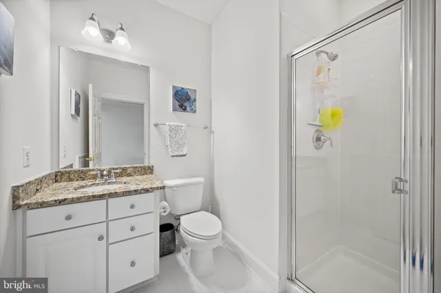 a bathroom with a granite countertop sink toilet and shower
