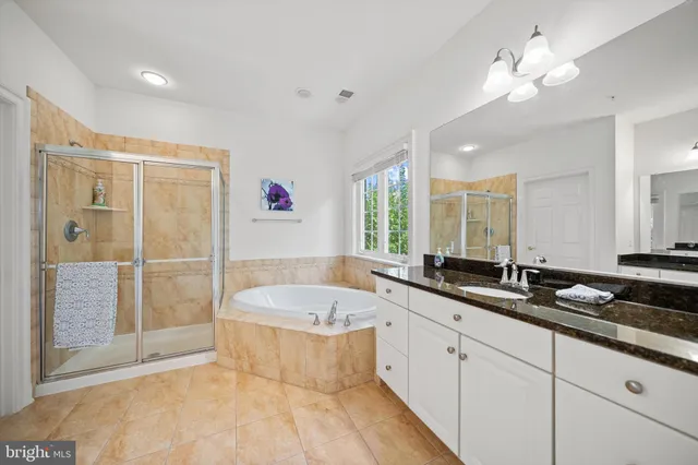 a spacious bathroom with a granite countertop tub sink shower and mirror