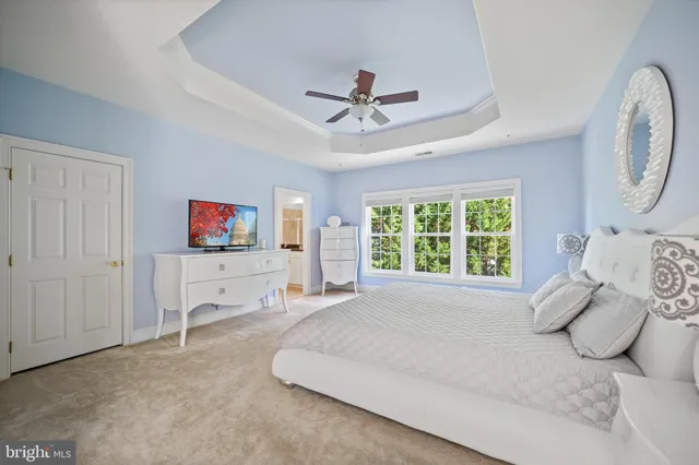a spacious bedroom with a bed and a chandelier