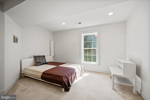 a bedroom with a bed chair and window