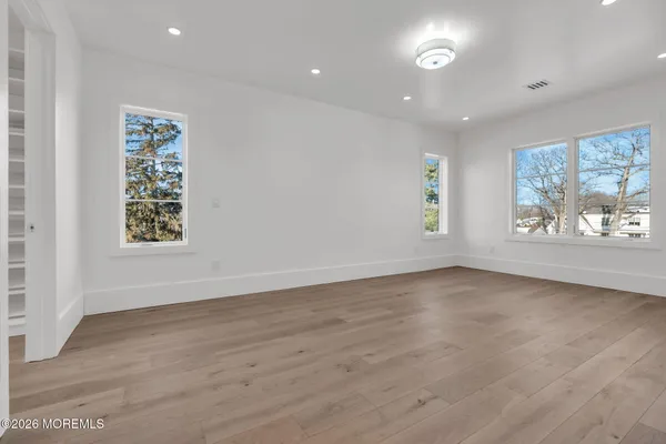a view of hallway with wooden floor and cabinet