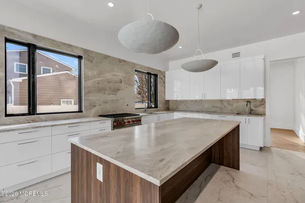 a kitchen with stainless steel appliances granite countertop a sink a oven and a granite counter tops with white cabinets