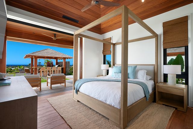 a bedroom with a large bed and a potted plant