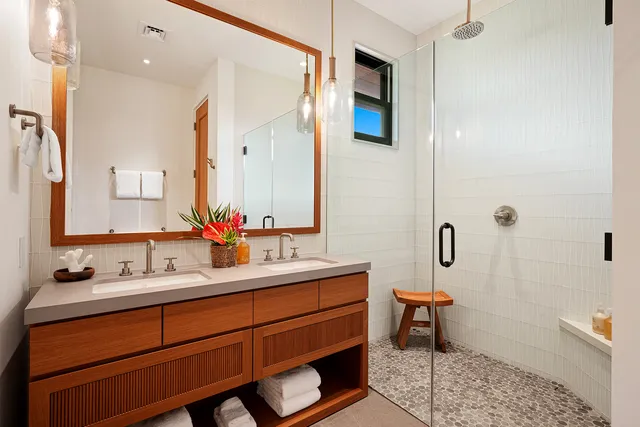 a bathroom with a double vanity sink a mirror and a bathtub