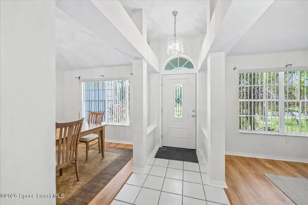 a view of a hallway with windows and chandelier