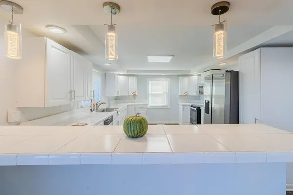 a view of a kitchen center island and stainless steel appliances