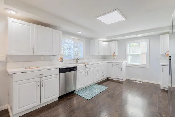 a kitchen with wooden floors and white appliances