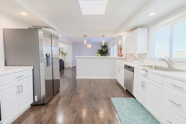 a kitchen with white cabinets and stainless steel appliances