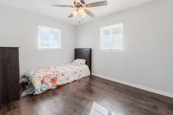 a bedroom with a bed and wooden floor