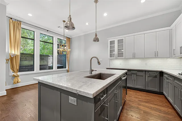 a kitchen with kitchen island a sink stainless steel appliances and cabinets