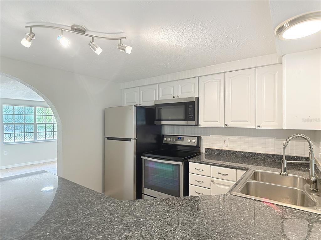 7827 Butler Avenue Hudson, FL 34667 - Photo 15 of 82 a kitchen with granite countertop a refrigerator sink and stove