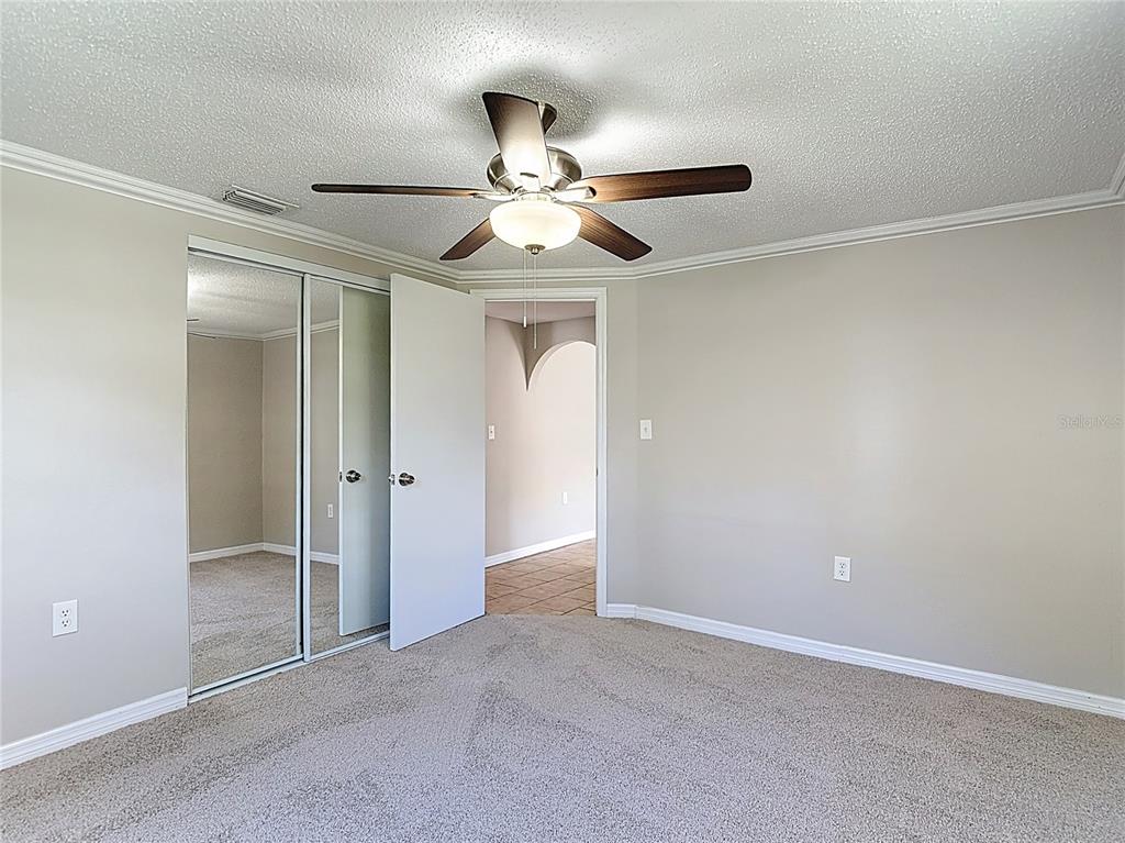 7827 Butler Avenue Hudson, FL 34667 - Photo 25 of 82 an empty room with closet and a chandelier fan