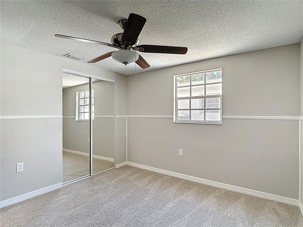 7827 Butler Avenue Hudson, FL 34667 - Photo 28 of 82 an empty room with windows and ceiling fan