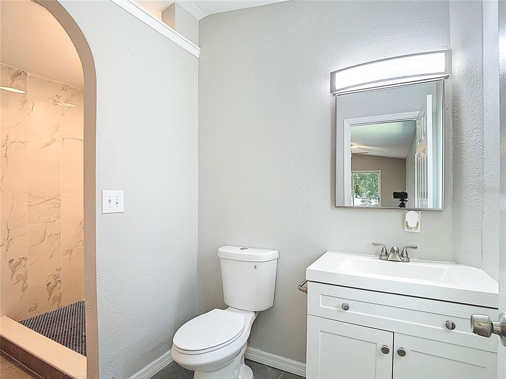 7827 Butler Avenue Hudson, FL 34667 - Photo 48 of 82 a bathroom with a toilet a sink a vanity and mirror