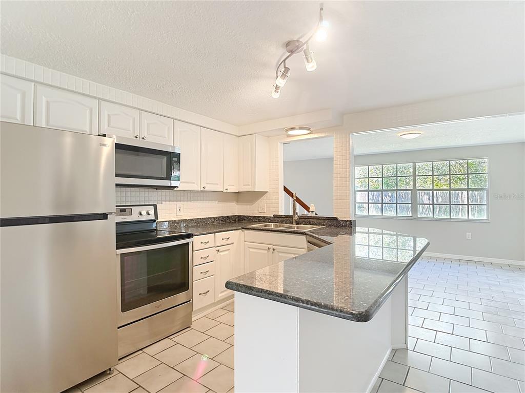 7827 Butler Avenue Hudson, FL 34667 - Photo 9 of 82 a kitchen with stainless steel appliances granite countertop a stove a sink dishwasher a refrigerator and a microwave