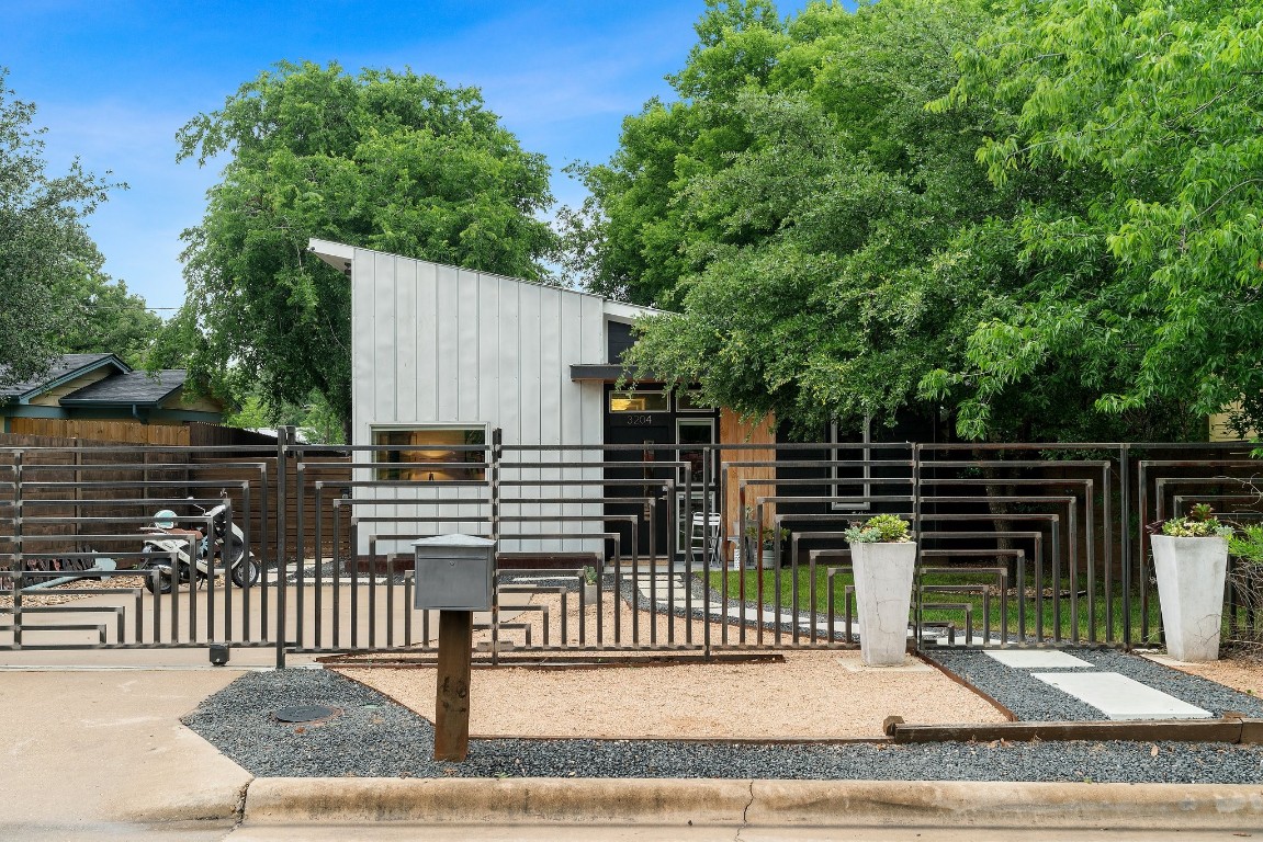 On arrival, the custom metal fence, rolling driveway gate, beautifully xeriscaped exterior will draw you in.