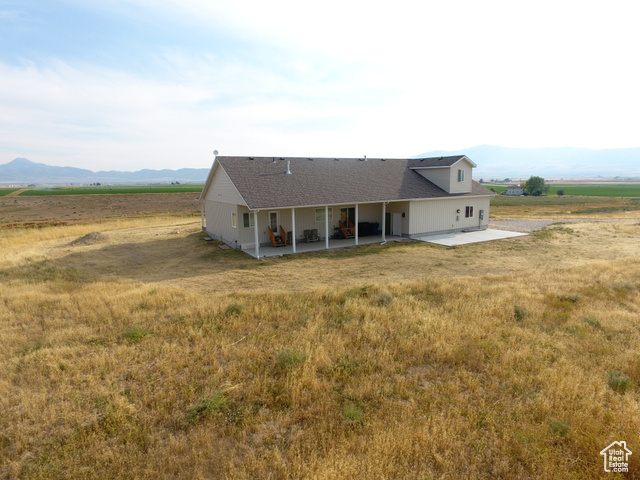 19502 South Olson Road Downey, ID 83234 - Photo 55 of 64 View of front of house with a mountain view, a view of countryside, a patio area, and a shingled roof