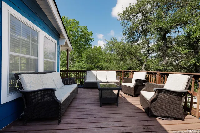 a balcony with wooden floor and outdoor seating